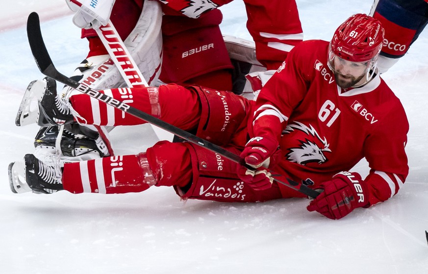 Le gardien lausannois Tobias Stephan, gauche, et le defenseur lausannois Fabian Heldner, centre, luttent pour le puck avec l&#039;attaquant zuerichois Chris Baltisberger, droite, lors du match du cham ...