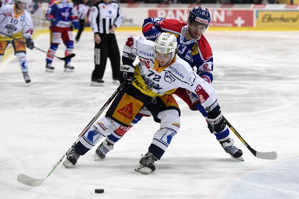 Der Zug Spieler Samuel Erni, links, im Kampf um den Puck gegen den Kloten Spieler Patrick Obrist, rechts, in der Schweizer National League A Partie zwischen dem EHC Kloten und dem EV Zug in der Swiss  ...