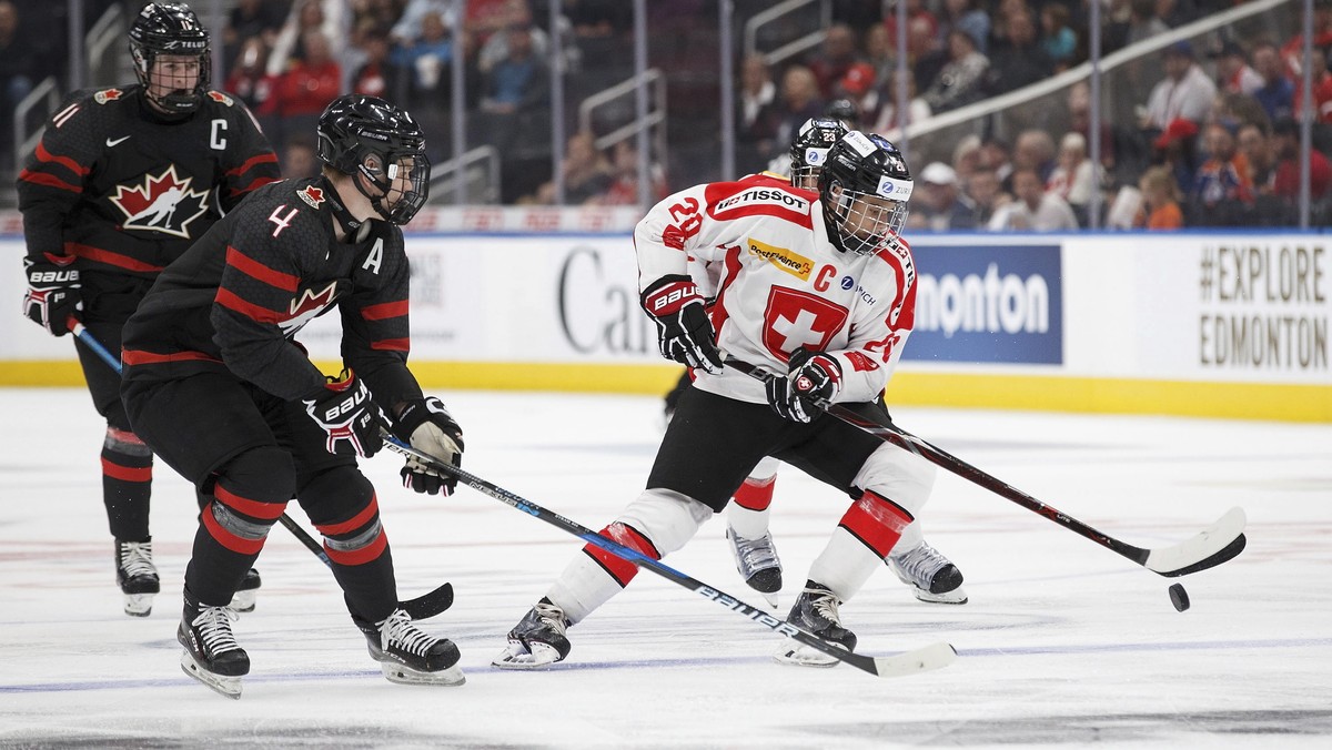 Canada's Bowen Byram (4) pursues Switzerland's Theo Rochette (20) during second period round-robin Hlinka Gretzky Cup hockey action in Edmonton, Alberta, Monday, Aug. 6, 2018. (Codie McLachl ...