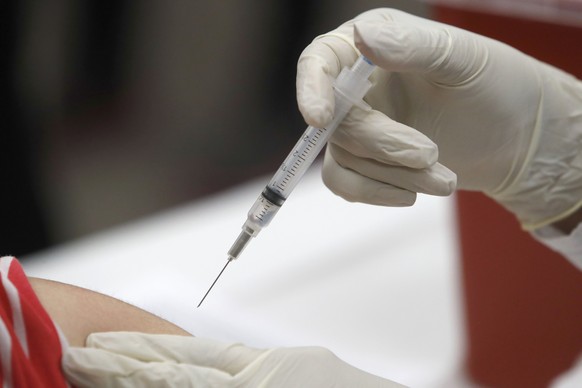 FILE - In this Thursday, Jan. 23, 2020, file photo, a patient receives an influenza vaccine in Mesquite, Texas. Amid all the focus on COVID-19 vaccinations, U.S. health experts have another plea: Don� ...