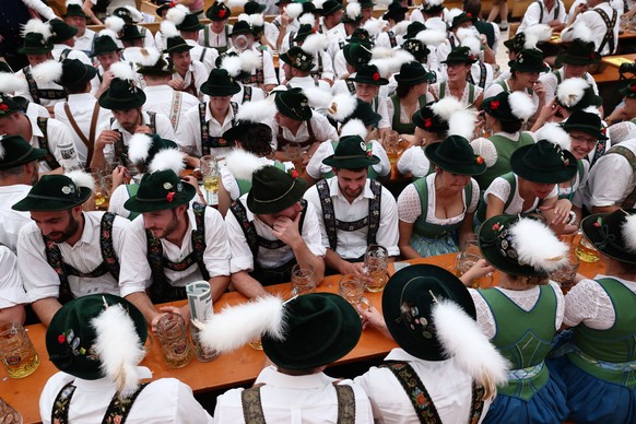 epa11619032 Musicians in traditional costumes drink beer as they gather in a tent after a parade during the 189th edition of the Oktoberfest beer and amusement festival in the German Bavaria state&#03 ...
