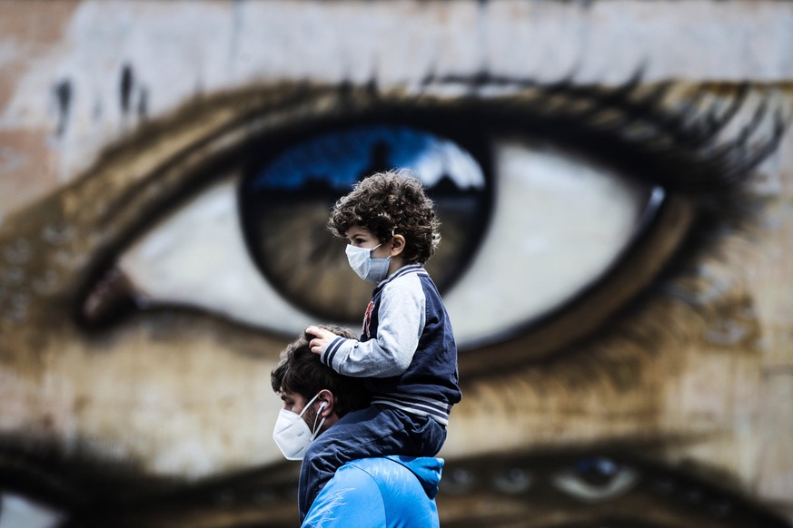 epaselect epa08395544 A person wearing a face mask walks in front of a grafitti mural amid the ongoing pandemic of the COVID-19 disease caused by the SARS-CoV-2 coronavirus in Rome, Italy, 01 May 2020 ...