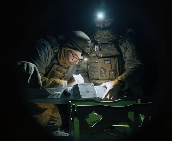 Ukrainian soldiers prepare a drone.