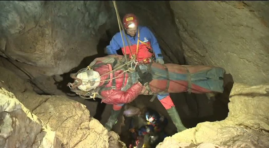 epa04267284 A handout video grab made available by the Bavarian Mountain Rescue on 19 June 2014 shows members of the rescue team transporting cave explorer Johann Westhauser through the Riesending cav ...