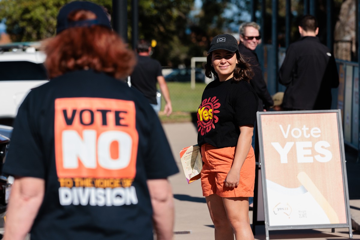 epa10918079 Yes and No campaigners stand outside Doubleview Primary School voting center in Perth, Australia 14 October 2023. Australians will participate in a historic referendum on 14 October to dec ...