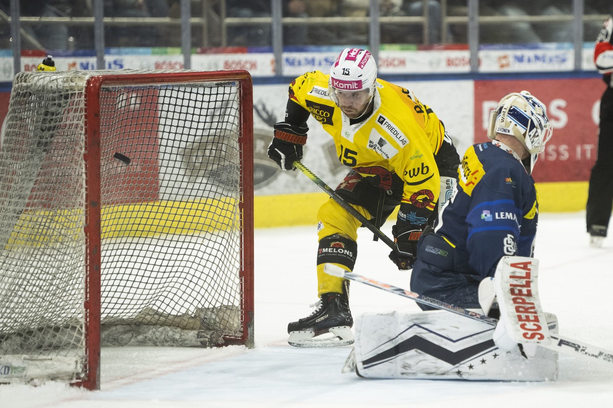 From left, Bern's player Oscar Lindberg scores the 2-4 goal against Ambri's goalkeeper Janne Juvonen, during the preliminary round game of National League A (NLA) Swiss Championship 2022/23  ...