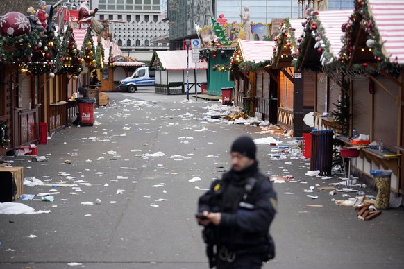 A police officer stands at a cordoned-off Christmas Market, where a car drove into a crowd on Friday evening, in Magdeburg, Germany, Saturday, Dec. 21, 2024. (AP Photo/Ebrahim Noroozi)