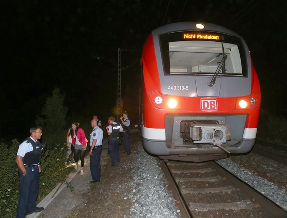 epa05431115 Police stand by the regional train on which a man allegedly wielding an axe attacked passengers in Wuerzburg, Germany, 18 July 2016. Reports state that a man allegedly wielding an axe inju ...