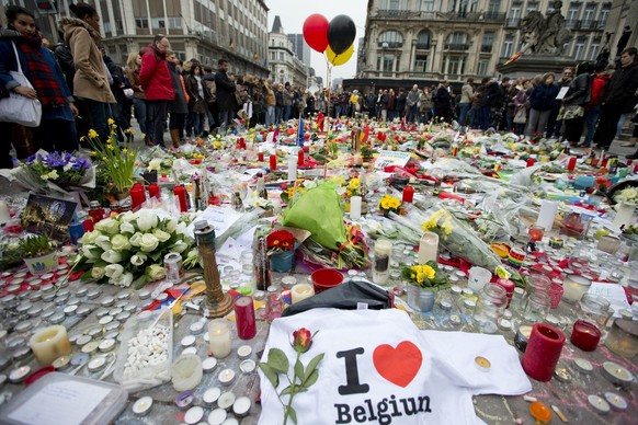 Three balloons in the colors of the Belgian flag fly as people mourn for the victims of the bombings at the Place de la Bourse in the center of Brussels, Belgium, Thursday, March 24, 2016. The Islamic ...