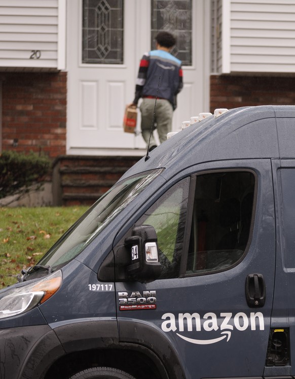 epa10309106 An Amazon (AMZN Nasdaq) delivery driver leaves a package at a home in Burlington, Massachusetts, USA, 16 November 2022. The Seattle based company has begun layoffs in its corporate ranks,  ...
