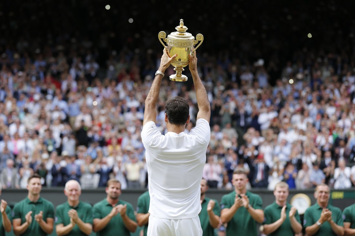 Roger Federer of Switzerland celebrates with the trophy after winning the men's final match against Marin Cilic of Croatia during the Wimbledon Championships at the All England Lawn Tennis Club,  ...