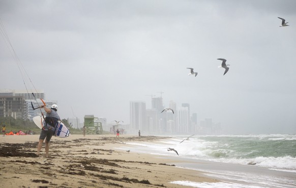 epa05572975 Matt Pollock prepares to go kitesurfing in Miami Beach, Florida, USA, 06 October 2016. Hurricane Matthew is expected to skim Florida&#039;s coast later in the day, after crossing over part ...