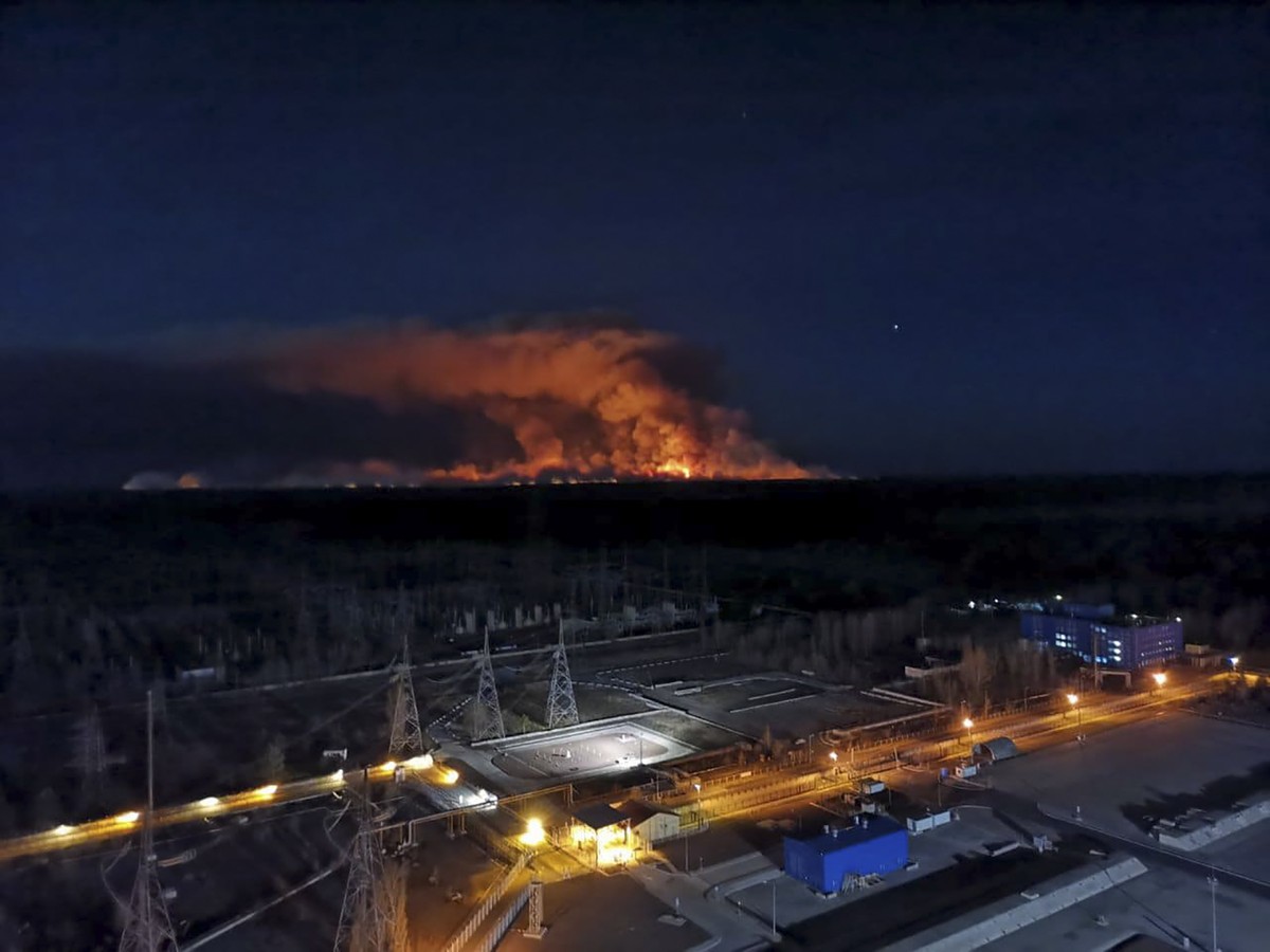 In this photo taken from the roof of Ukraine's Chernobyl nuclear power plant late Friday April 10, 2020, a forest fire is seen burning near the plant inside the exclusion zone. Ukrainian firefigh ...
