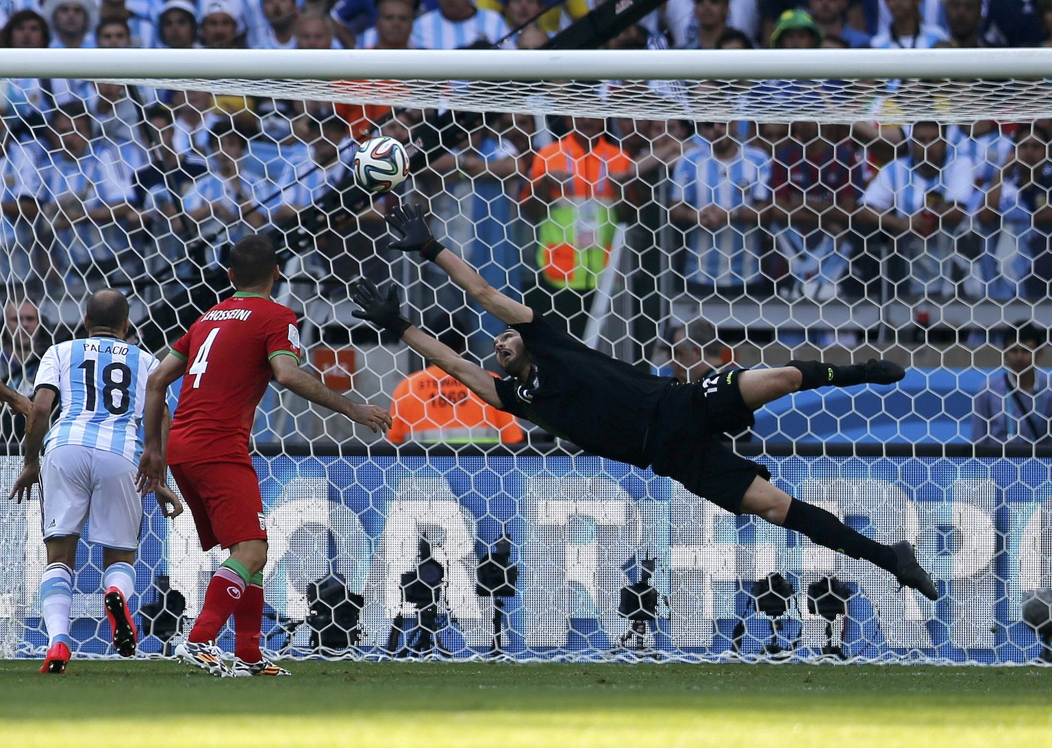 Haghighi streckt sich vergebens. Dieser Schuss von Messi ist eine Achtelfinal-Quali wert