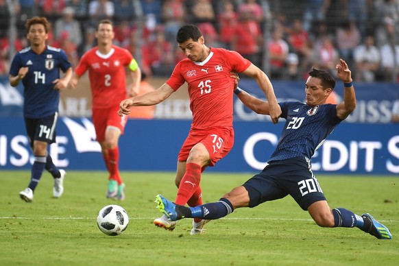 Switzerland&#039;s Blerim Dzemaili, left, in action against Japan’s Tomoaki Makino, right, during an international friendly soccer match in preparation for the upcoming 2018 Fifa World Cup in Russia b ...