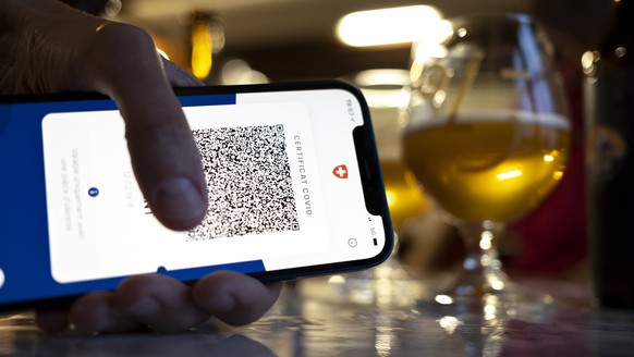 Une personne tient dans sa main un smartphone avec l&#039;application Certifact Covid suisse dans un restaurant ce vendredi 10 septembre 2021 a Rances dans le canton de Vaud. Des ce lundi 13 septembre ...