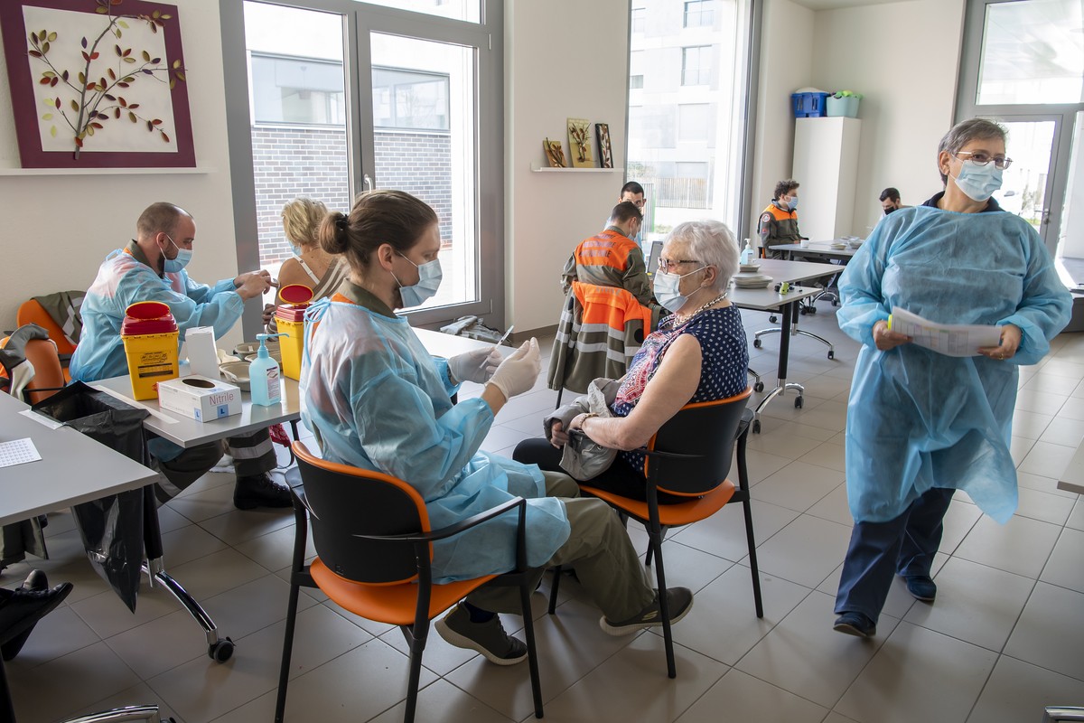 Des membres d'une equipe mobile de vaccination de la protection civile vaudoise, PC, vaccine des femmes a l'aide du vaccin Pfizer-BioNTech dans les logements proteges Les Saules, lors du der ...