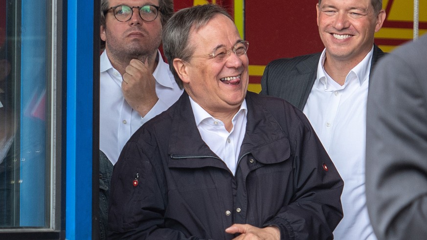Laschet lacht während einer Ansprache des Bundespräsidenten zur deutschen Flutkatastrophe im Juli 2021.
