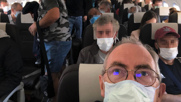 Passagiere mit Masken in einem Flugzeug der Swiss auf dem Flug von Zürich nach Lissabon am 17. Mai 2020.
