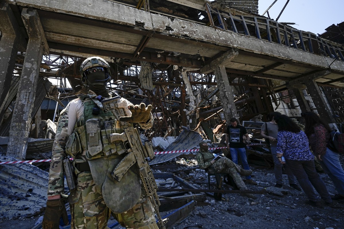 FILE - A Russian soldier speaks to foreign journalists in front of the ruined Metallurgical Combine Azovstal, in Mariupol, on the territory which is under the Government of the Donetsk People's R ...