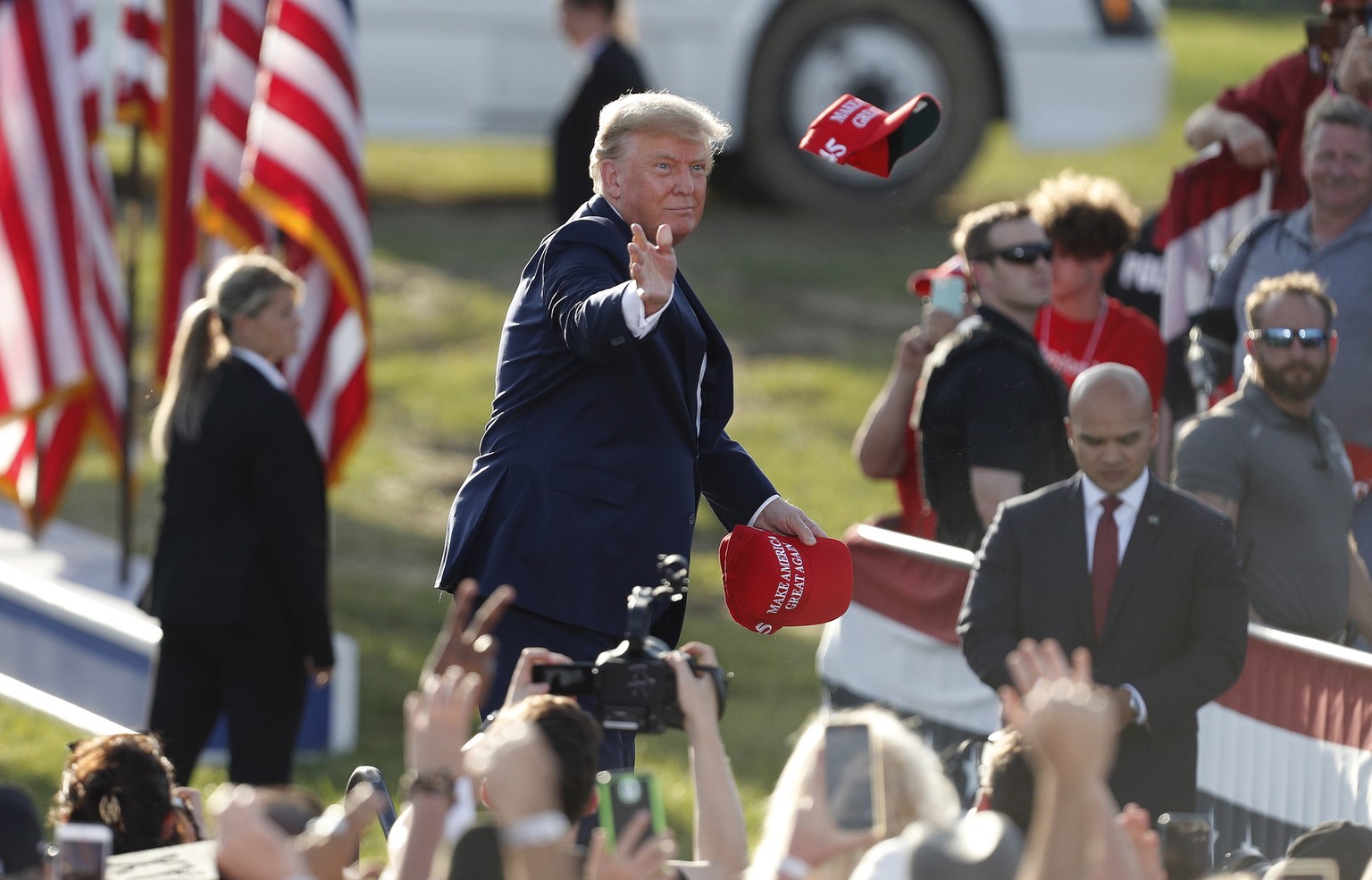 epa09905591 Former US President Donald Trump tosses MAGA hats to the crowd as he arrives for a Save America rally at the Delaware County Fairgrounds in Delaware, Ohio, USA, 23 April 2022. EPA/DAVID MA ...
