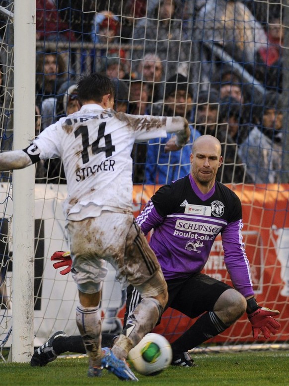 Basels Valentin Stocker, links, gegen Tuggens Goalie Adrian Bernet, rechts, beim Fussball Cup 1/8-Finalspiel FC Tuggen gegen den FC Basel am Sonntag, 10. November 2013, in Tuggen. (KEYSTONE/Sebastian  ...