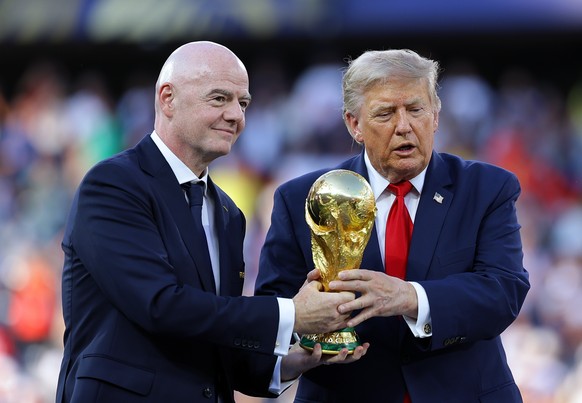 epa13121893 FIFA president Gianni Infantino (L) and US president Donald Trump hand over the trophy to Spain after they won the FIFA World Cup 2026 final match Spain against Argentina, in New Jersey, U ...