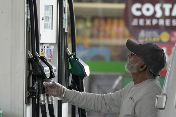 FILE - A driver looks at the petrol pump at a petrol station in London, Thursday, June 9, 2022. Britain���s new Prime Minister Liz Truss has pledged to rebuild the economy, but she faces a daunting jo ...