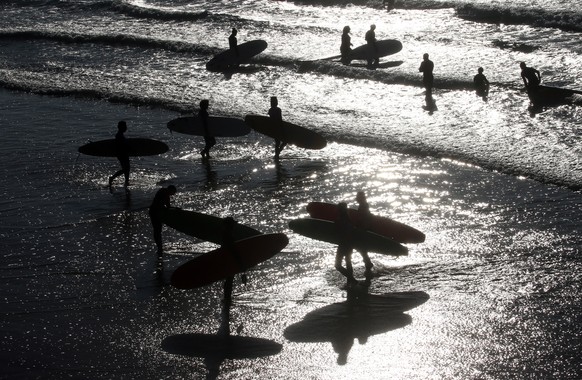 Surfers in the Atlantic Ocean in Biarritz, southwestern France, Wednesday, Oct.27, 2021. Temperatures in southwestern France reached 20 degrees Celsius (68 Fahrenheit). ( AP Photo/Bob Edme)