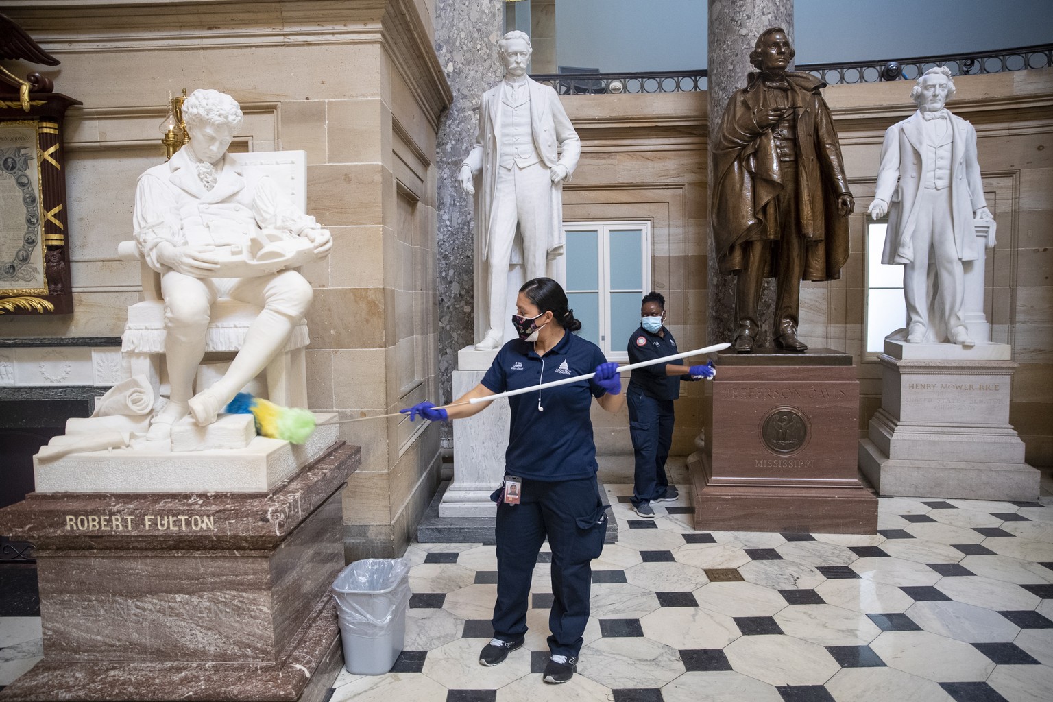 epa08925002 A cleaning crew dusts residue from the pedestals of the statues in Statuary Hall inside the US Capitol in Washington, DC, USA, 07 January 2021, the morning after various groups of Presiden ...