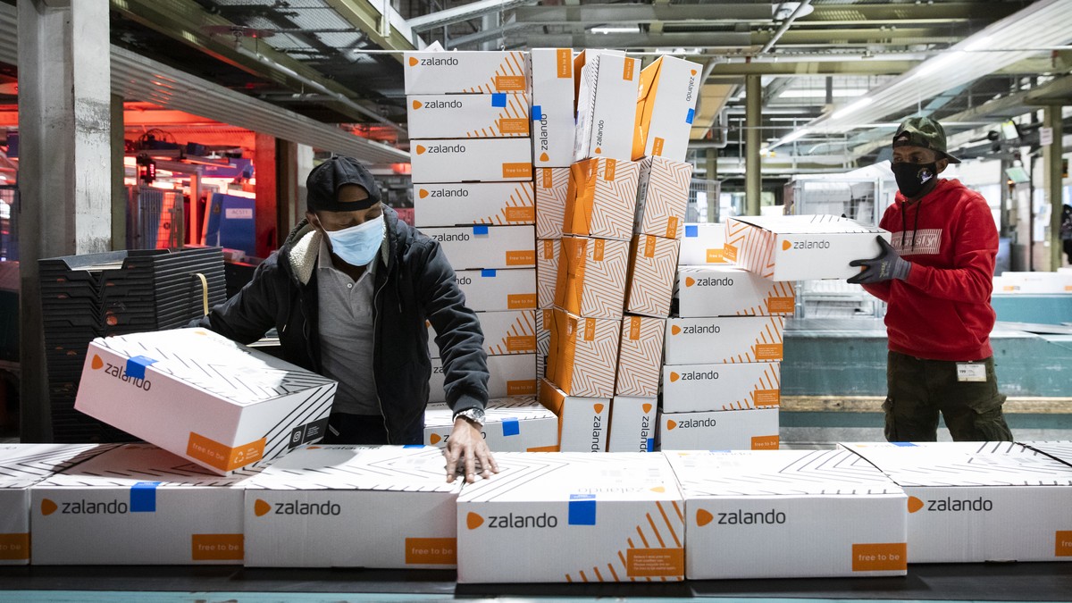 Angestellte der Post packen angelieferte Pakete der Firma Zalando auf ein Laufband im Paketzentrum Haerkingen, am Mittwoch, 9. Dezember 2020, in Haerkingen. (KEYSTONE/Peter Klaunzer)