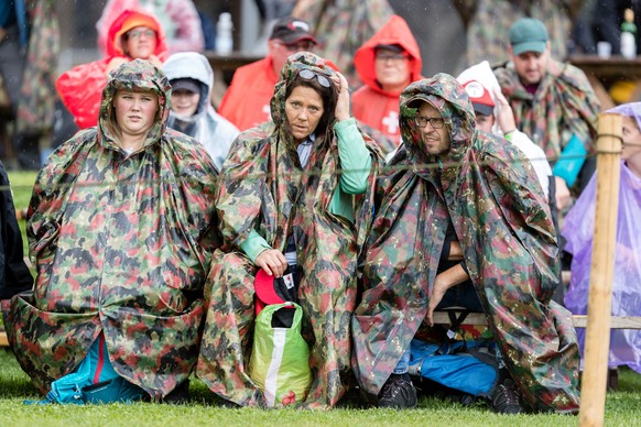 Zuschauer sitzen im Regen beim Ob- und Nidwaldner Kantonal Schwingfest am Sonntag, 22. August 2021 in Giswil. (KEYSTONE/Philipp Schmidli)