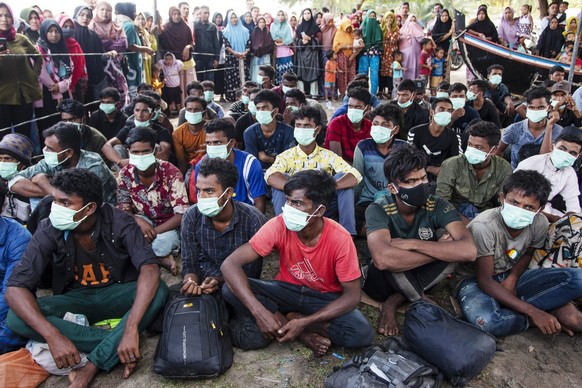 Ethnic Rohingya people sit at a temporary shelter in North Aceh, Indonesia, Wednesday, Nov. 16, 2022. Over 100 Rohingya Muslims traveling in a wooden boat have landed on an Indonesian beach, the secon ...