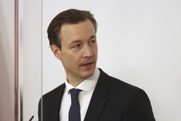 Austrian Finance Minister Gernot Bluemel speaks behind plexiglass shields during a press conference at the federal chancellery in Vienna, Austria, Tuesday, Feb. 16, 2021. (AP Photo/Ronald Zak)