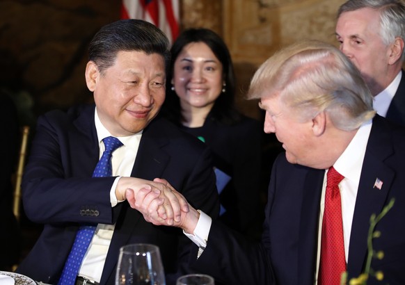 FILE - In this April 6, 2017 file photo, President Donald Trump, right, shakes hands with Chinese President Xi Jinping during a dinner at Mar-a-Lago, in Palm Beach, Fla. Trump begins a state visit to  ...