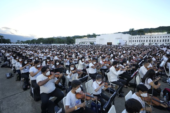 Members of the National Orchestra System play a 12-minute Tchaikovsky piece to try and break a Guinness World Record in Caracas, Venezuela, Saturday, Nov. 13, 2021. The musicians, all connected with t ...