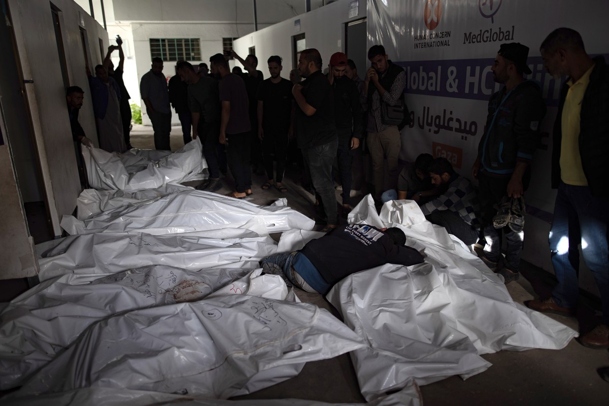 epa11372934 Palestinians mourn next to the bodies of their relatives after an Israeli army raid on a camp at an area designated for displaced people in Rafah, southern Gaza Strip, 27 May 2024. At leas ...