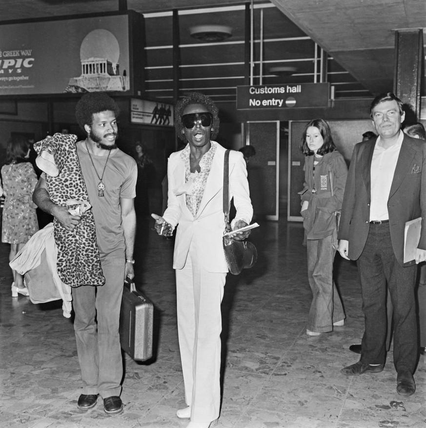 American jazz musician James Mtume (left) and trumpeter Miles Davis (1926 - 1991) arrive at Heathrow Airport in London, UK, 10th July 1973