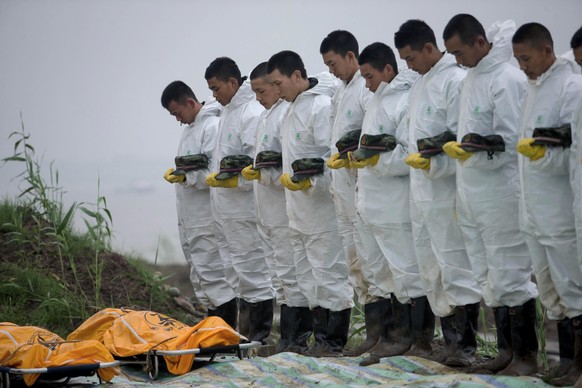 Chinesische Retter legen eine Schweigeminute ein.