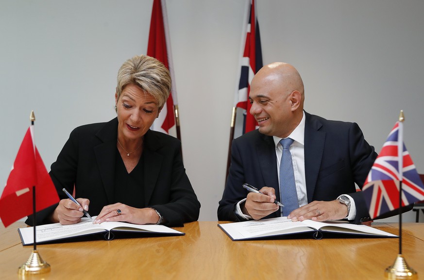 Swiss Minister of Justice Karin Keller-Sutter and Britain&#039;s Home Secretary Sajid Javid sign a contract about security cooperation in London, Wednesday, July 10, 2019. (AP Photo/Frank Augstein)