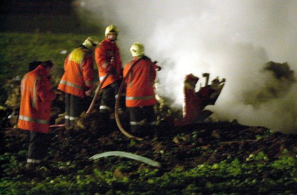 Fire fighters extinguish the debris of a Saab 340 Crossair plane which crashed near Nassenwil Niederhasli shortly after take-off from Zuerich-Kloten airport, Monday, January 10, 2000. All seven passen ...
