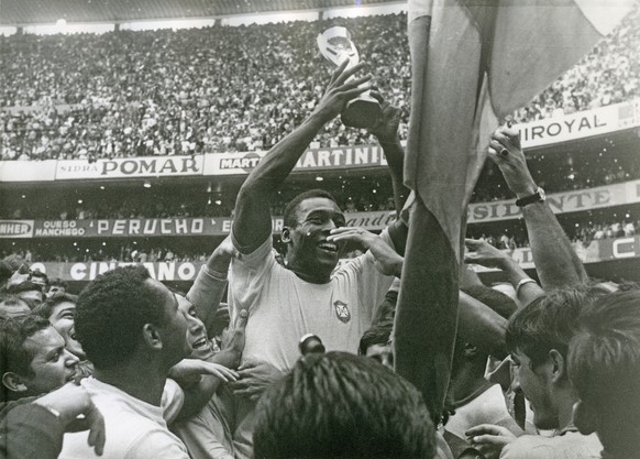 Brazil's Pele (Edson Arantes do Nascimento) has a big smile as he holds the Jules Rimet Trophy, following Brazil's 4-1 victory over Italy in the World Cup finals at the Azteca Stadium in Mex ...