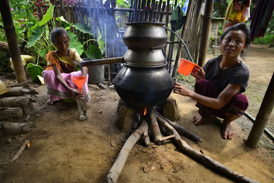 epa07048362 Tiwa tribal women prepare local rice beer during the annual Lanhkhon festival in Karbi Anglong district of Assam state, India, 25 September 2018 (issued 26 September 2018). This festival i ...