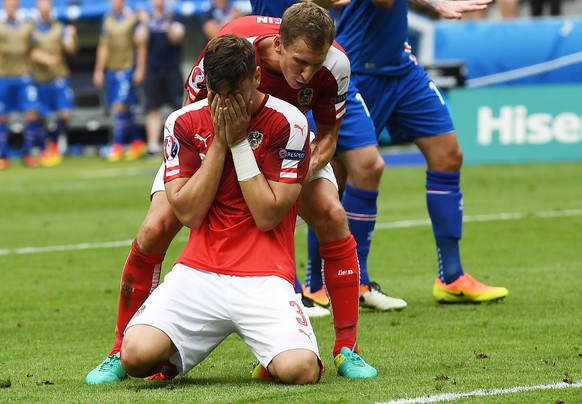 epa05383894 Aleksandar Dragovic of Austria is comforted by teammate Florian Klein after failing to score with a penalty during the UEFA EURO 2016 group F preliminary round match between Iceland and Au ...