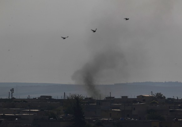 In this photo taken from the Turkish side of the border between Turkey and Syria, in Akcakale, Sanliurfa province, southeastern Turkey, smoke billows from targets in Tel Abyad, Syria, during bombardme ...