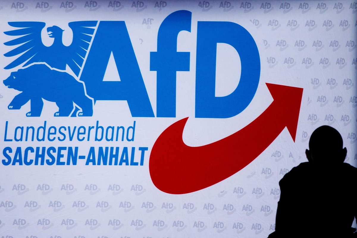 epa13214902 A person stands in front of the logo of the Alternative for Germany party (AfD) regional party in Saxony-Anhalt during the final campaigning event of the Alternative for Germany party (AfD ...