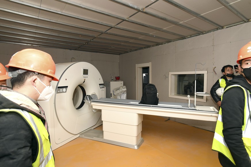 People walk near a CT scanner in a room at the Huoshenshan temporary field hospital in Wuhan in central China's Hubei Province, Sunday, Feb. 2, 2020. The Philippines on Sunday reported the first ...