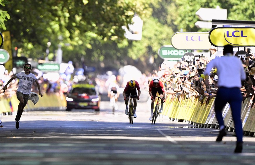 A demonstrator pictured as Norwegian Jonas Abrahamsen of Uno-X Mobility and Swiss Mauro Schmid of Team Jayco AlUla sprint to the finish of stage 11 of the 2025 Tour de France cycling, from and to Toul ...