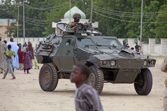 File - In this file photo taken Thursday, Aug. 8, 2013, a Nigerian soldier patrols in an armored car, during Eid al-Fitr celebrations, in Maiduguri, Nigeria. Graphic new video footage from northeaster ...