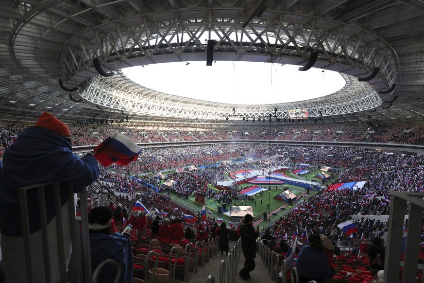 Participants wave Russian national flags during the &#039;&#039;Glory to the Defenders of the Fatherland&#039;&#039; concert waiting for Russian President Vladimir Putin, a day before the Defender of  ...